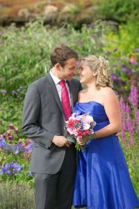 Image of a happy man in a suit and a smiling woman in a blue dress on their wedding day